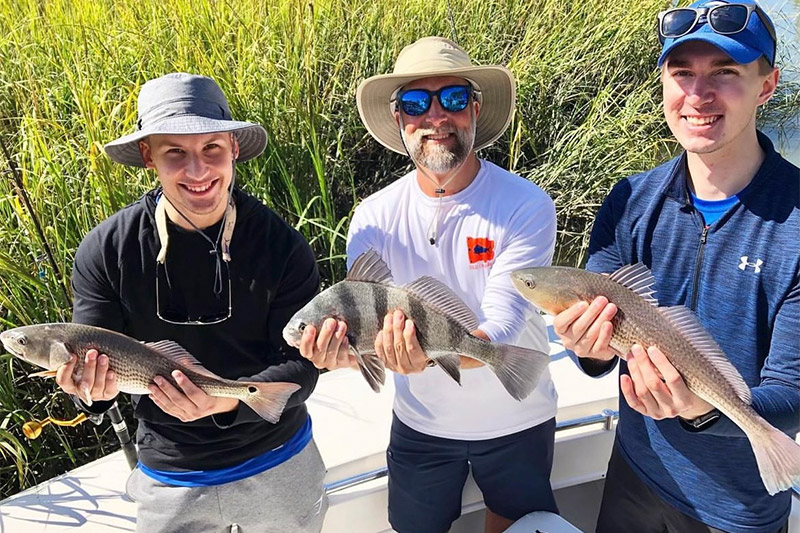 Family catching a variety of fish during inshore fishing trip in Charleston