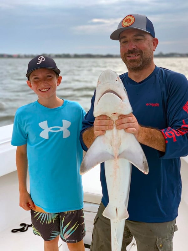Father and son with large shark pulled in from Charleston Harbor