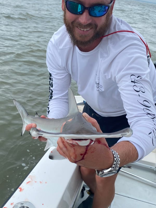 Captain Jesse Riddle holding a Hammerhead shark caught during Charleston fishing trip