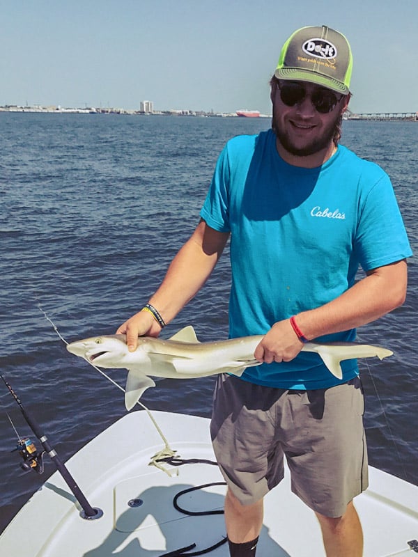 Man holding a shark caught in Charleston Harbor
