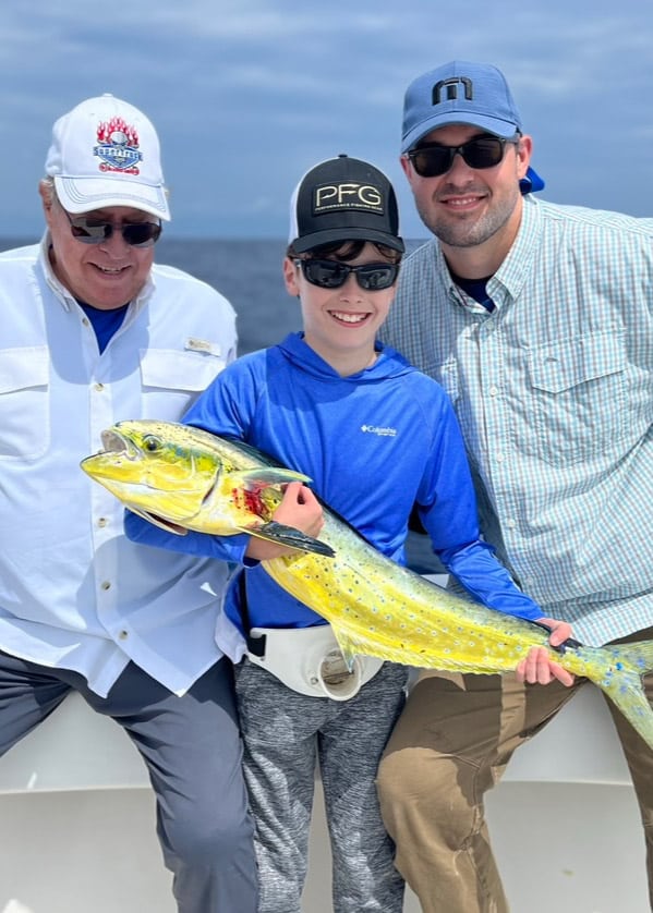 Grandfather, Father, and Son family fishing trip caught dolphin